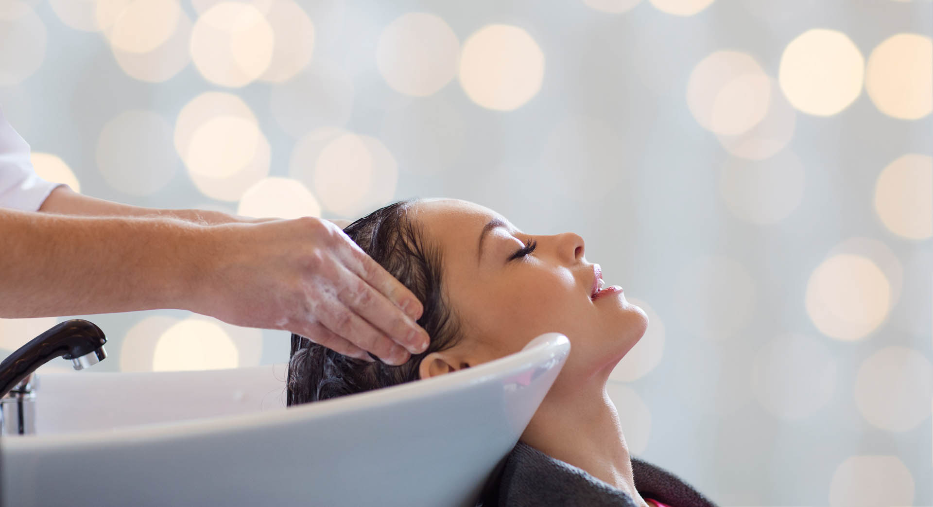 happy young woman having salon hair wash